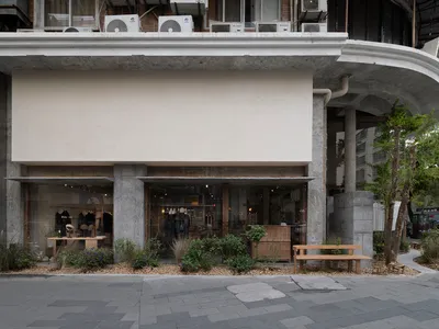 Concrete storefront with glass windows and a simple, minimalist design.