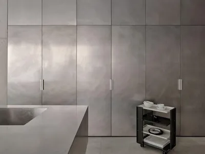A streamlined, modern kitchen with metallic cabinetry and a large countertop.