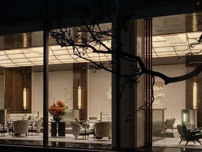 Minimalist hotel lobby featuring stone, glass, and metal materials.