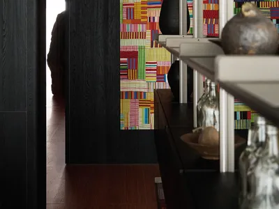 A colorful wall pattern with black furniture in a living room setting.