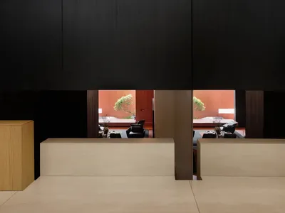 Modern restaurant interior with wooden columns and seating arrangements.