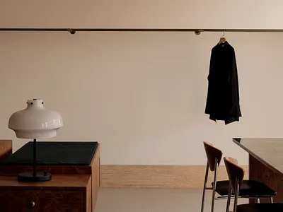 A modern home office featuring a wooden desk, chair, and lamp.