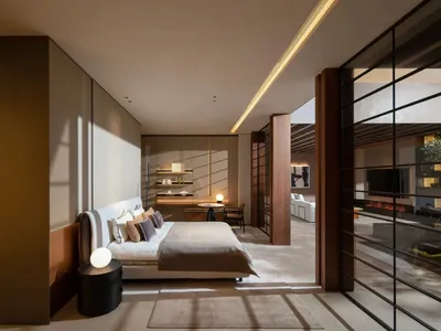 A modern bedroom with a white bed and neutral-colored decor, featuring a glass wall with a green plant.