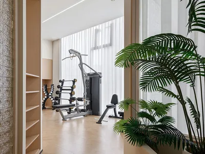 A room with a minimalist home office setup, featuring wooden furniture and large windows.