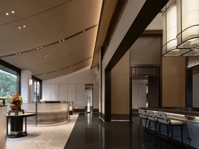 A modern hotel reception area featuring metallic finishes and minimalist design.
