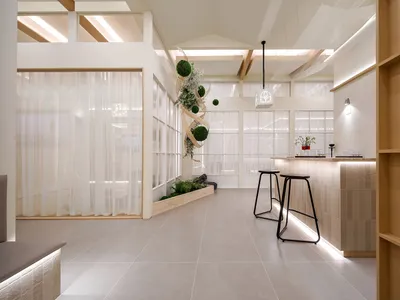 A minimalist restaurant interior featuring glass elements, concrete walls, and wooden accents.