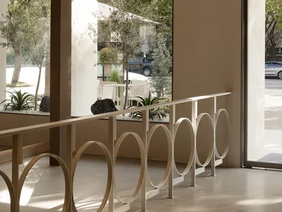 Modern restaurant interior with concrete, glass, and wooden elements.