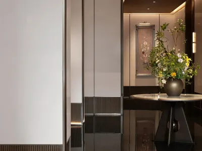 A minimalist hotel entrance featuring black glass panels.