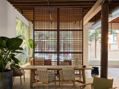 Indoor living room with wooden furniture, plants, and a large window