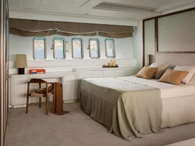 Modern bedroom with minimalistic design, featuring fabric bedding, wooden headboard, and stainless steel fixtures.