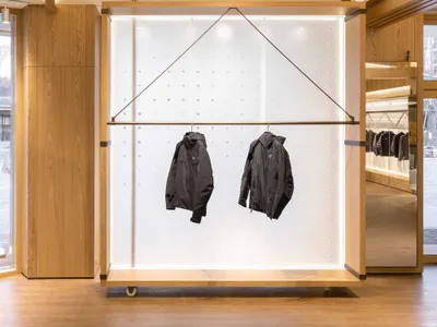 服裝店室內，展示木質層架與玻璃展示櫃。