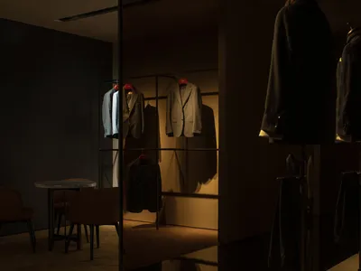 服飾店展示區，衣架上懸掛著西裝，搭配簡約設計元素。