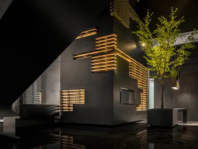 現代酒店大廳，採用深色金屬包覆與發光木條設計。