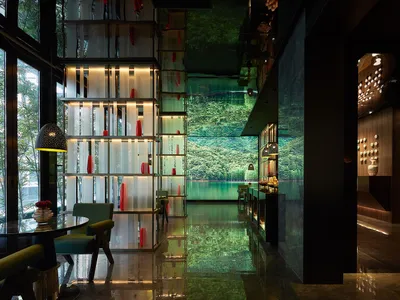 Modern minimalist hotel lobby featuring glass walls and stone flooring