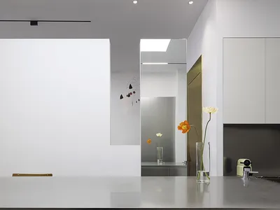 A minimalist kitchen featuring steel countertops and glass cabinets.