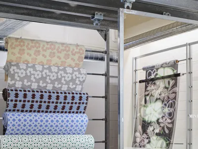 A display of colorful fabric rolls in a showroom setting.