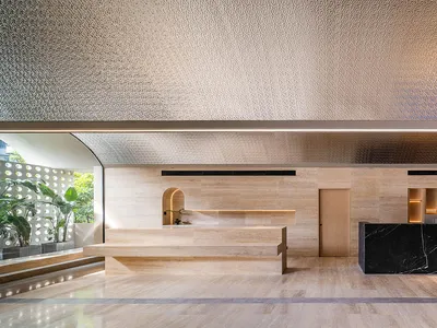 A modern hotel reception desk featuring marble and wood materials.