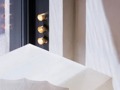 A modern bedroom with a textured, neutral-colored bedspread on a white platform bed.