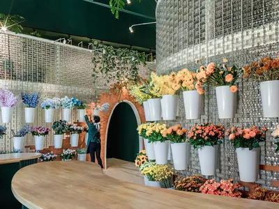 A modern restaurant interior with wooden tables and greenery