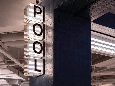 A minimalist hotel lobby with tiled walls and glass features.