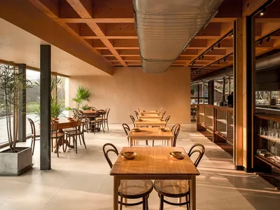 A modern restaurant interior featuring sustainable wood and glass materials.