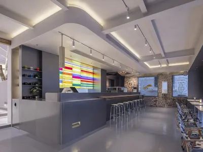 Modern restaurant interior with concrete, glass, and metal elements.