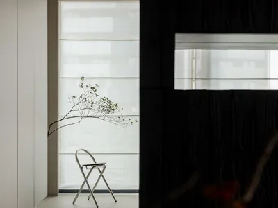 A minimalist bedroom with a modern metal chair and minimalist decor.