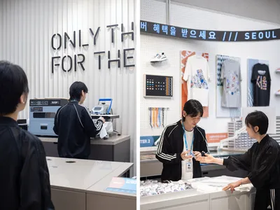 Retail space for custom t-shirt printing with a variety of shirts and printing equipment on display.