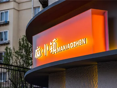 Modern, illuminated restaurant signage with Chinese characters and English text.
