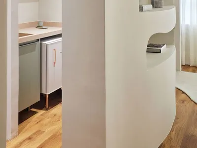 Modern minimalist kitchen with white walls, shelves, and cabinets.