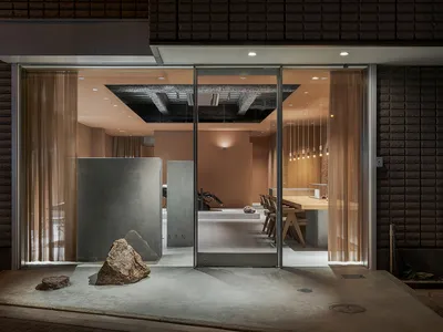 A minimalist hotel entry with concrete surfaces and a modern design.