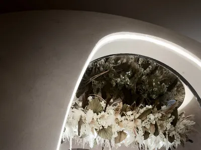 簡約餐廳室內空間，展示大型複雜的乾燥花卉植物裝置。