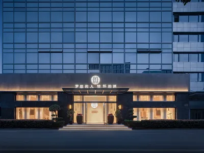 現代優雅的酒店外觀，搭配玻璃立面與混凝土細節。