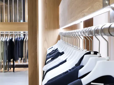 服裝店室內空間，搭配木製展示櫃與金屬衣架