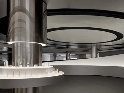 A modern retail storefront featuring a curved glass facade and metal elements.