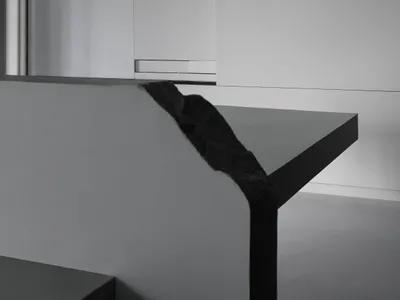 A minimalist bedroom with a concrete floor and walls, featuring a sleek design and modern style.