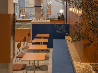 Modern cafe interior with concrete walls, wooden tables, and industrial lighting