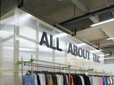 現代工業風格的服裝零售展示，展示架上陳列著各色襯衫。
