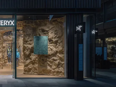 現代零售店面，玻璃牆面搭配混凝土質感，展示 Arc'teryx 品牌標誌。