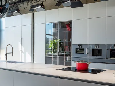 Modern kitchen with white laminate countertops and cabinets, sleek design.