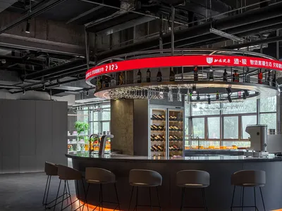 Industrial-style restaurant bar with concrete counter and glass shelves.