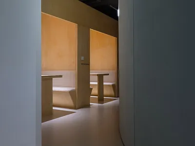 Modern restaurant interior with wooden furnishings and seating.
