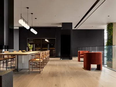 Industrial lounge featuring wooden floors, metal accents, and greenery.