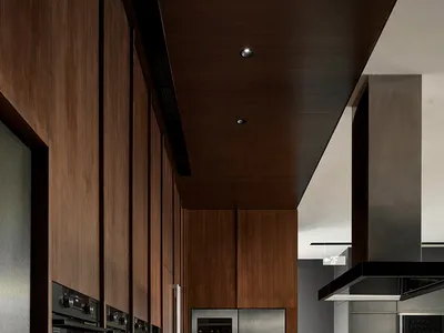 Modern kitchen with wooden cabinets, stainless steel appliances, and a white countertop.