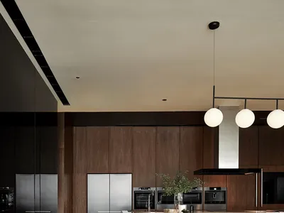 A modern kitchen featuring wooden cabinets, stainless steel appliances, and a concrete countertop.