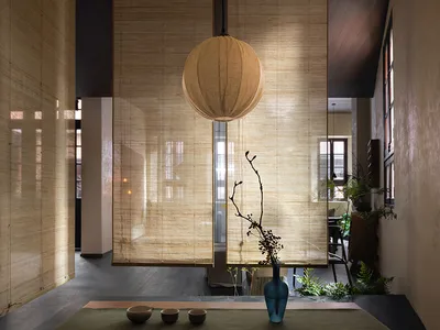 Minimalist living room featuring bamboo furniture and natural light from large windows.