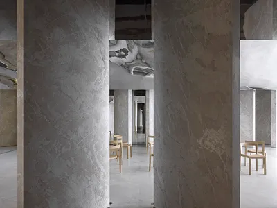 Modern restaurant interior featuring marble walls and floors.