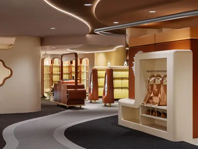 A modern retail store with a curved design, featuring wooden shelves, glass display cases, and metal railings.