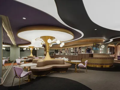 Modern restaurant cafe featuring metallic lighting, flooring, and leather furniture.