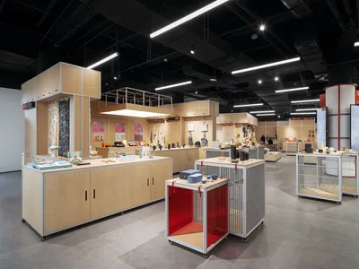 A retail space featuring craft items displayed on shelves and tables with a modern, minimalist design.
